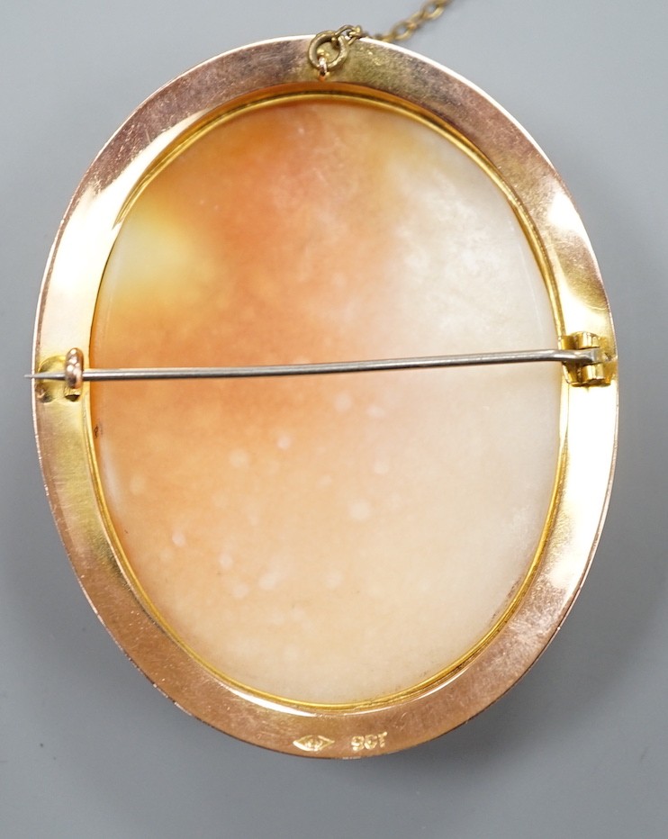 A 9ct mounted oval cameo shell brooch, carved with two ladies in a townscape, 58mm, gross weight 17.8 grams.